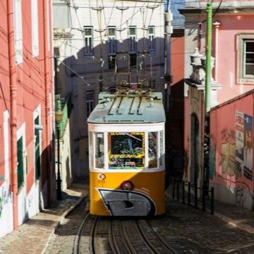 Un tram jaune dans une rue en pente de Lisbonne